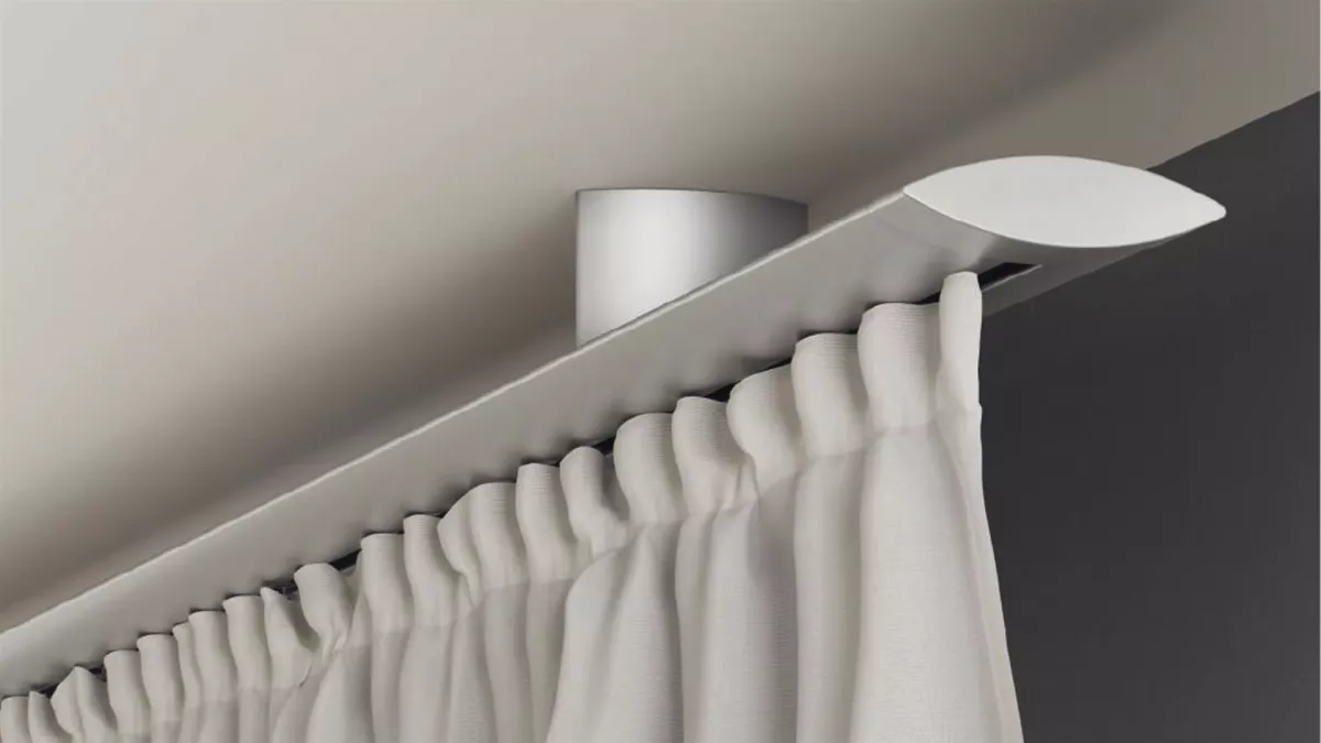 Silberfarbige Innenlauf-Gardinenstange an der Decke montiert mit einer weissen Gardine