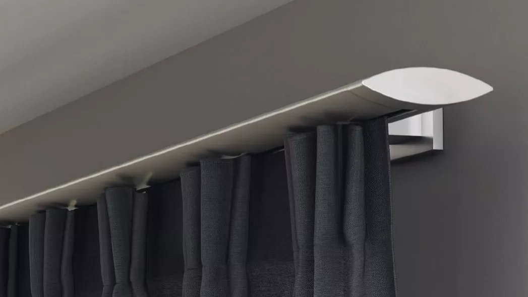 Silberfarbige Innenlauf-Gardinenstange an der Wand montiert mit einem dunklen Vorhang