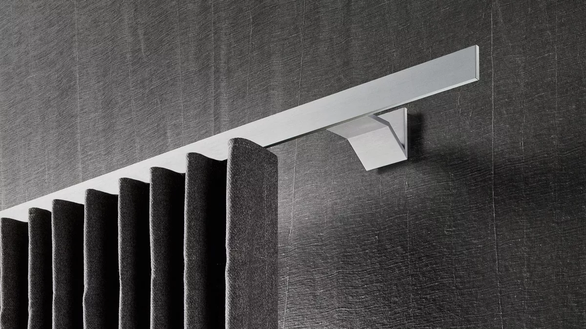 Interstil Gardinenstange in der Farbe Aluminium an der Wand montiert mit einem dunklen Vorhang