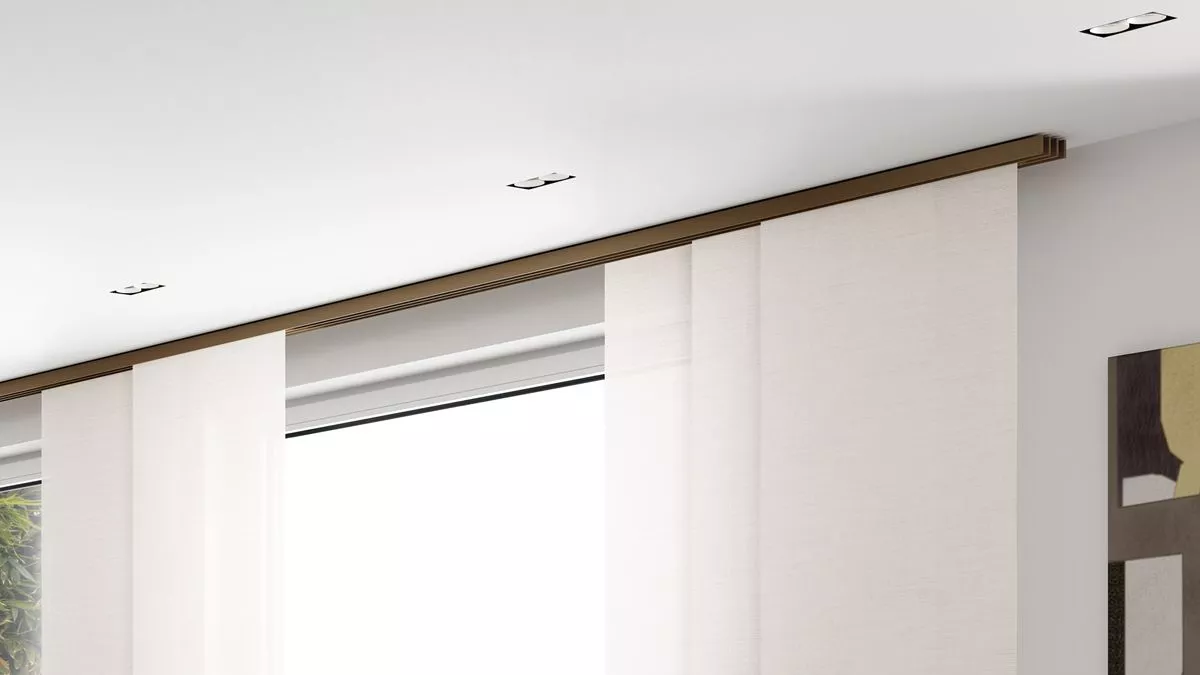 Flächenvorhangschiene F1 von Interstil in der Farbe Bronze als Deckensystem mit hellen, blickdichten Paneelen