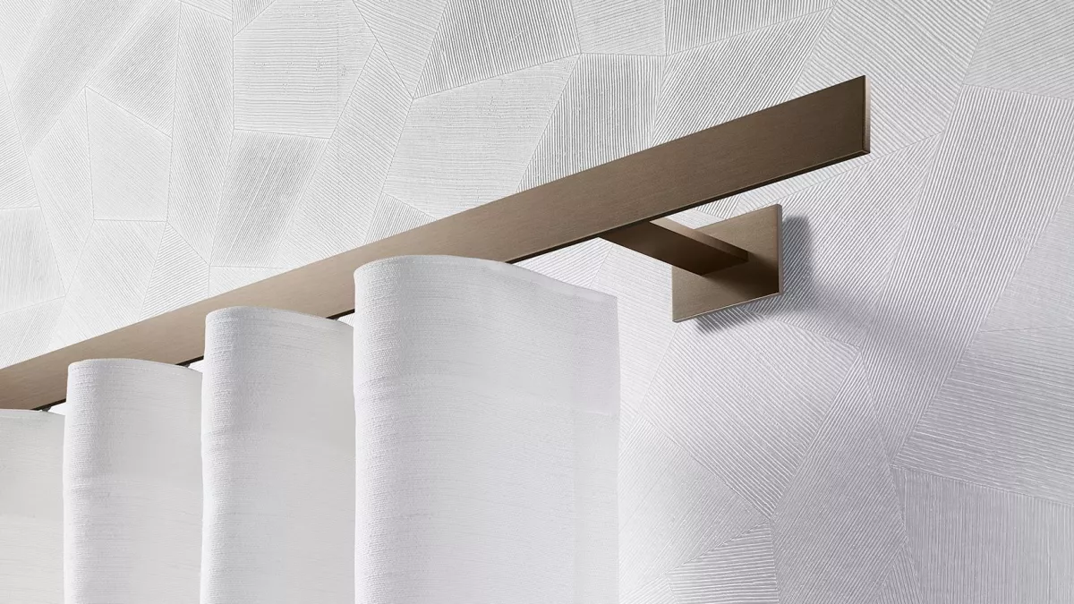 Interstil Gardinenstange Codex in der Farbe Bronze an der Wand montiert mit einem leichten Vorhang