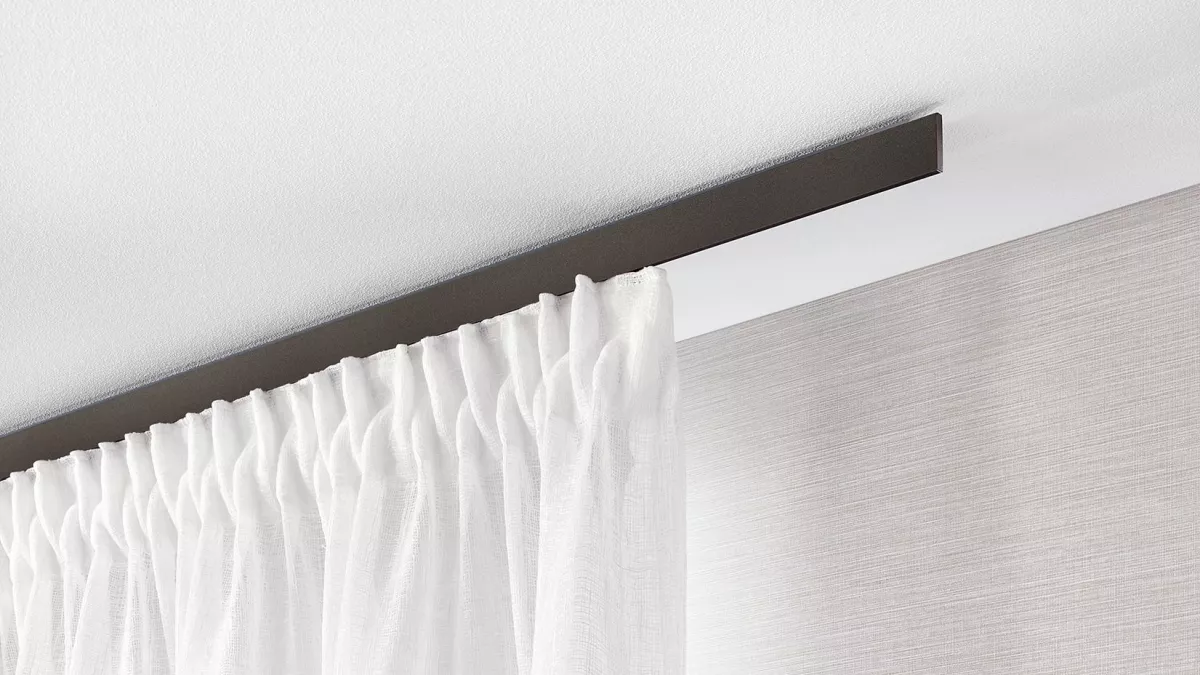 Interstil Gardinenstange Helix in der Farbe Anthrazit an der Decke montiert mit einem weissen, leichten Vorhang