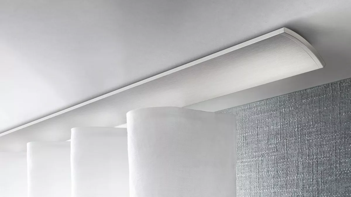 Interstil Gardinenstange W2 an der Decke vor einem Fenster montiert mit einem leichten, strukturierten Vorhang