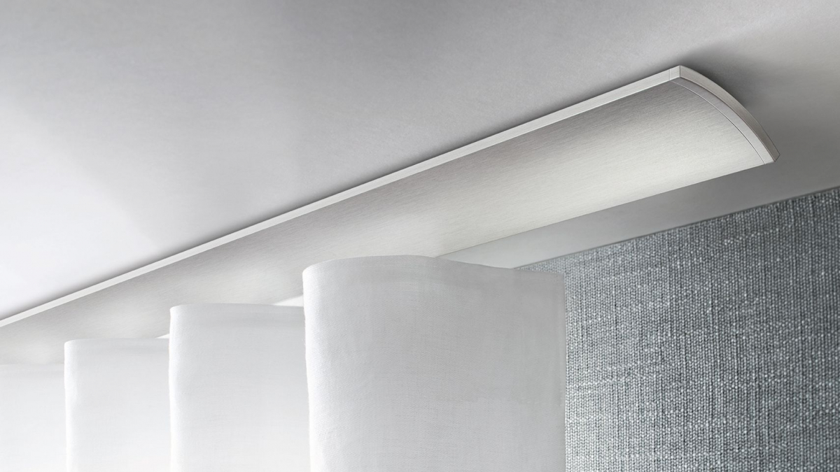 Interstil Gardinenstange W2 an der Decke vor einem Fenster montiert mit einem leichten, strukturierten Vorhang
